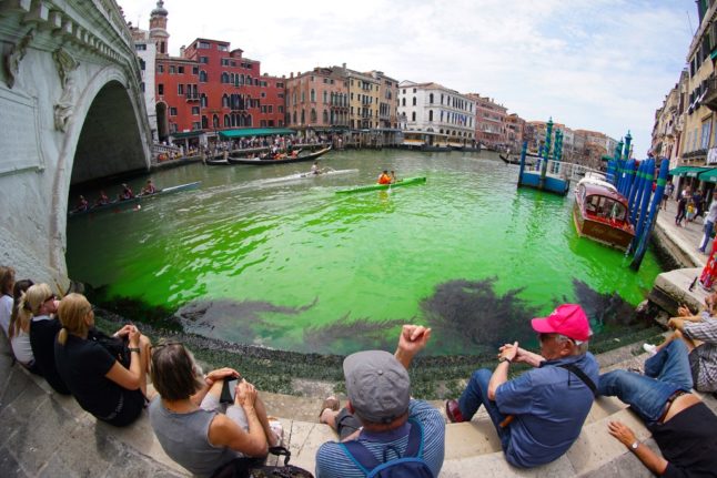 Fluorescent green waters below the Rialto Bridge in Venice's Grand Canal on May 28, 2023.