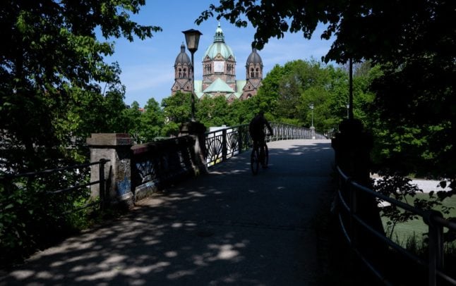 A man rides over a bridge on the Isar in Munich