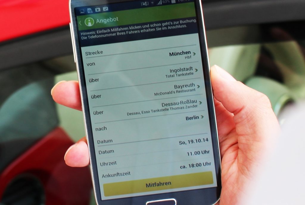 A man uses a carpooling app to look for rides from Munich to Berlin.