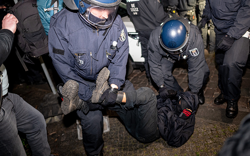 police deal with a masked protester at a take back the night demonstration in berlin