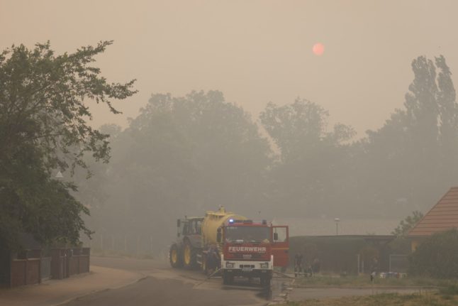 A firefighting vehicle is pictured as smoke from a wildfire is seen in Beelitz, southwest of Berlin, eastern Germany