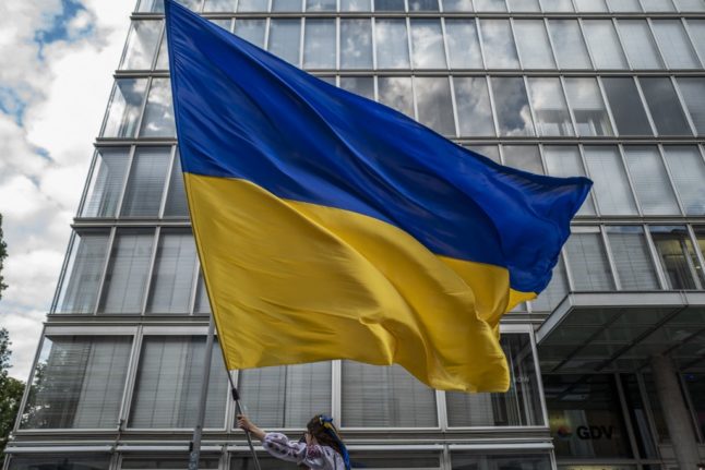 A protester displays a giant Ukrainian flag during a pro-Ukraine demonstration in Berlin.