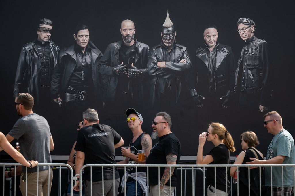 Fans of Rammstein music band queue under portraits of band members prior to a concert 