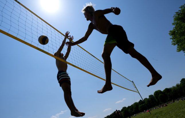 Friends play volleyball during a hot June day in Munich
