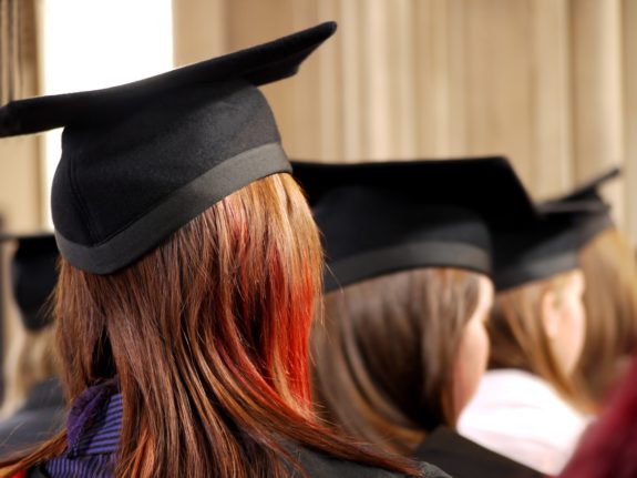 Pictured is back of the head shot of students at a graduation ceremony.