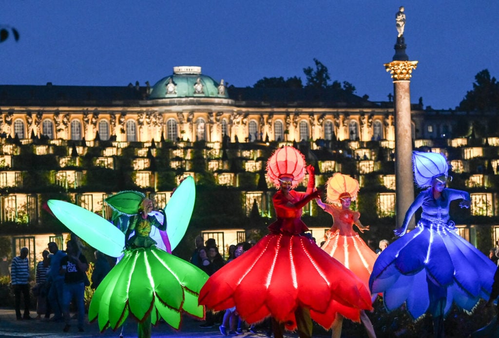Artists from the group "Flower Power" dance in Sanssouci Park at the Potsdam Palace Night 2022. 