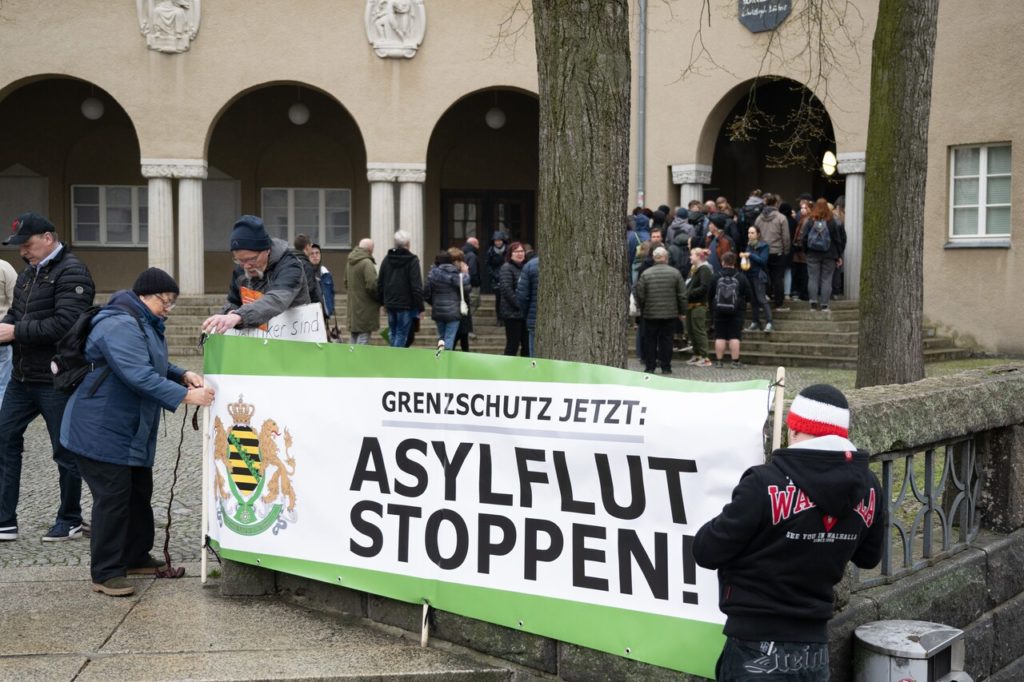 Participants of a rally of the right-wing extremist party Freie Sachsen (Free Saxony) hold a banner with the inscription "Asylflut Stoppen" (Stop the flood of asylum seekers) in Görlitz.