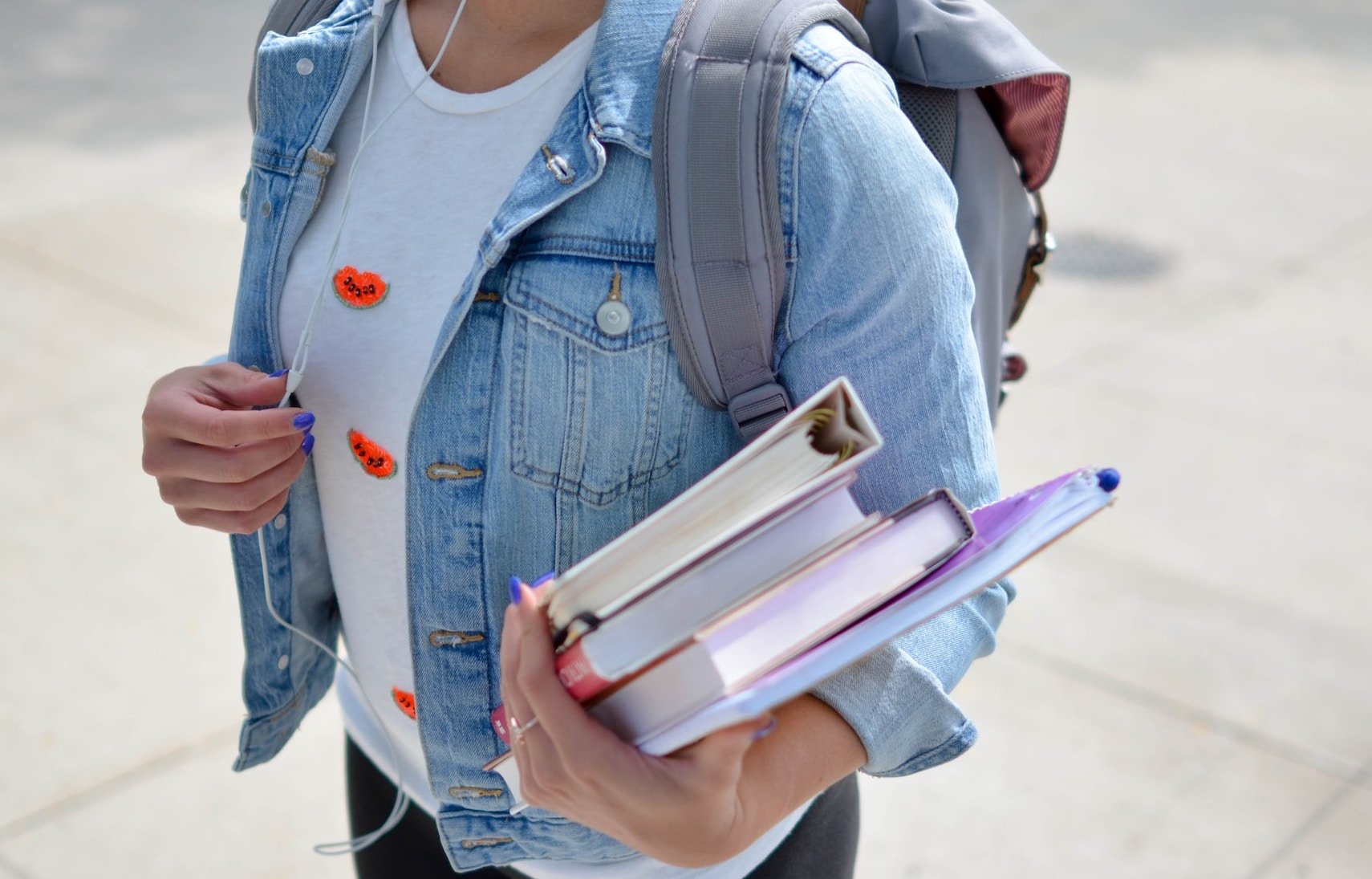 A student carries books. 