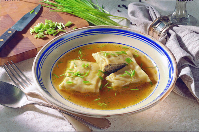 A plate of traditional Maultaschen in a broth sauce.