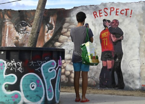 A man takes pictures of a Barcelona mural by Italian street artist Salvatore Benintende aka TvBoy which depicts Spanish Football Federation president Luis Rubiales kissing Spain midfielder Jenni Hermoso.