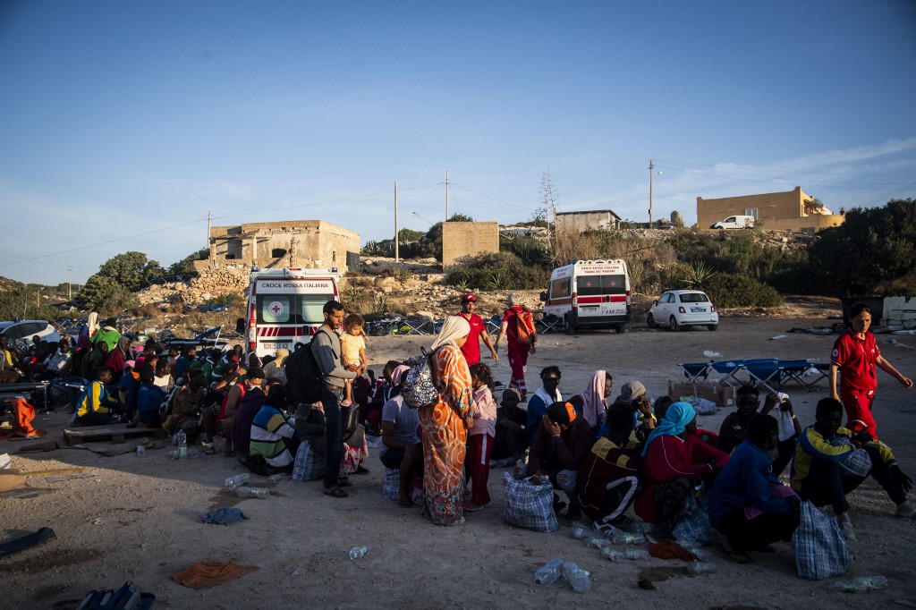 People gather outside the migrant reception centre on Lampedusa, south of Sicily, on August 14th 2023. The island has recently struggled to cope with a large number of sea arrivals. 