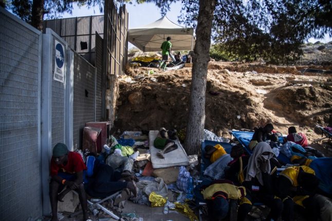 Migrants gather outside the operational centre on the Italian island of Lampedusa on September 15, 2023. The island's reception centre, built to house fewer than 400 people, was overwhelmed with men, women and children forced to sleep outside on makeshift plastic cots, many wrapped in metallic emergency blankets.