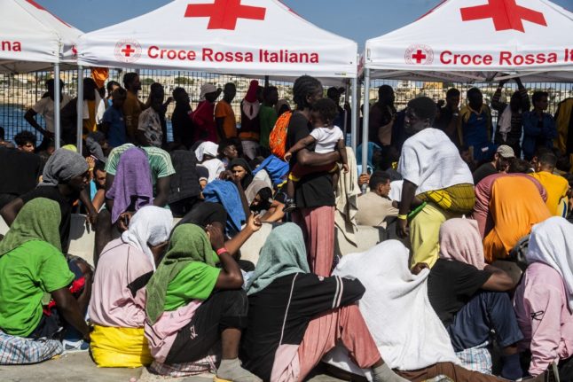 Migrants gather in the harbour of Italian island of Lampedusa, before being transferred to Porto Empedocle in Sicily region, south Italy, by the Italian military ship Cassiopea, on September 15, 2023. The island's reception centre has been overwhelmed this week.