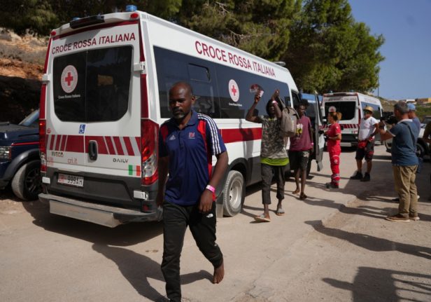 Migrants leave an Italian Red Cross vehicle after arriving on the island of Lampedusa on September 18, 2023.