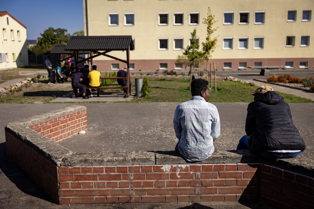 Residents sit in the courtyard between housing blocks at Brandenburg's Central Immigration Authority (ZABH) center, housing some 1400 asylum seekers in eastern Germany, on September 28, 2023. 