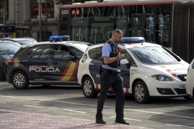 A Spanish police vehicle is parked next to a car of the Catalan regional police force Mossos d'Esquadra outside the Catalan police headquarters in Barcelona.