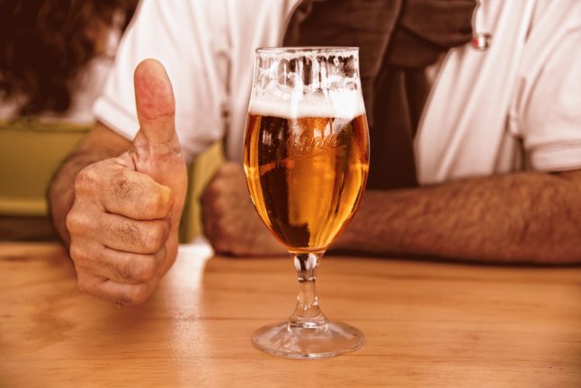 A person gives a thumbs up to beer