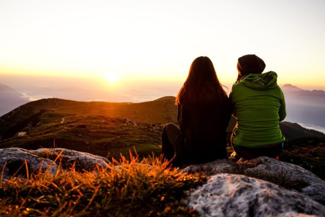 Two friends enjoy the view at the Dobratsch mountains in Austria.