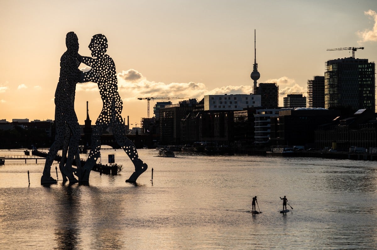 A view of the River Spree in Berlin, including the Molecule Man and TV tower landmarks.