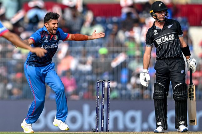 Afghanistan's Azmatullah Omarzai (L) celebrates after taking the wicket of New Zealand's Will Young (R) during the 2023 ICC Men's Cricket World Cup one-day international (ODI) match between New Zealand and Afghanistan in Chennai on October 18, 2023.