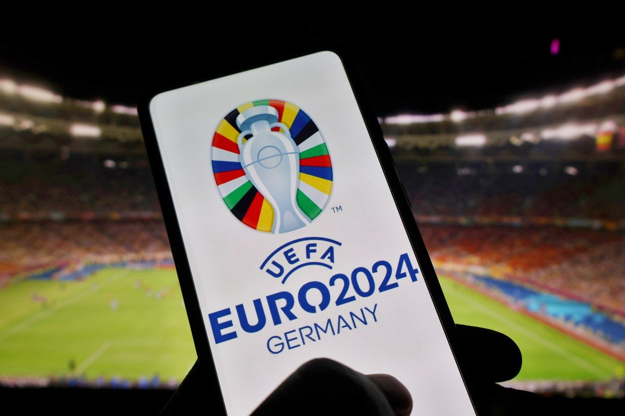 A smartphone displays the app and logo for the UEFA Euros 2024