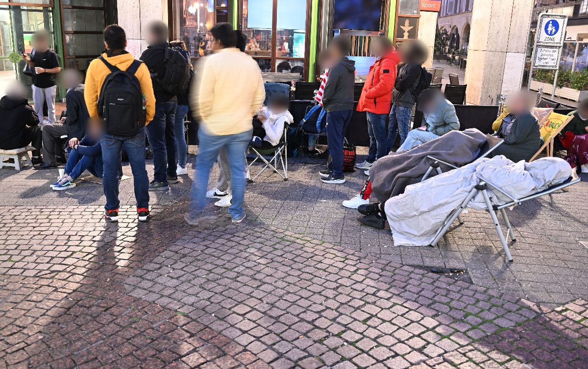 People wait in front of the immigration office in Stuttgart in the early hours of the morning for an appointment. 