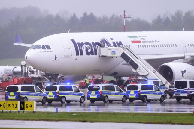 Police emergency vehicles stand in front of an Iran Air aircraft at Hamburg Airport. Flight operations at Hamburg Airport, which were suspended due to a threat of an attack on an Iranian aircraft from Tehran, have resumed.