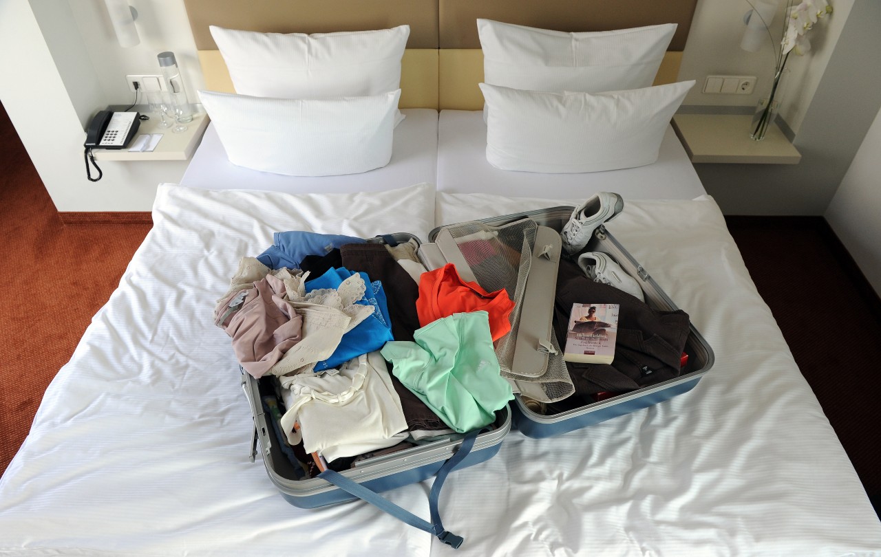 A suitcase on a hotel bed.