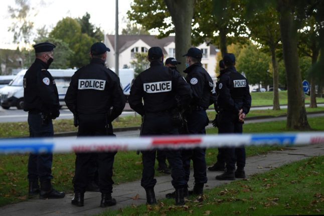 French police stand at cordoned-off during an investigation at the site where Monique Olivier is charged with helping abduct a young girl.