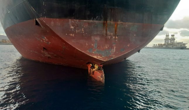 This handout picture from the Spanish coastguard shows three migrants on the rudder of Alithini II oil tanker off Las Palmas of Gran Canaria, after surviving an 11-day journey from Lagos to Spain's Canary Islands.