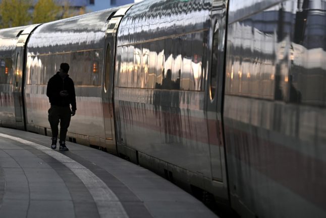 A man stands on a platform next to an ICE (Inter City Express) train at the main railway station in Berlin, Germany