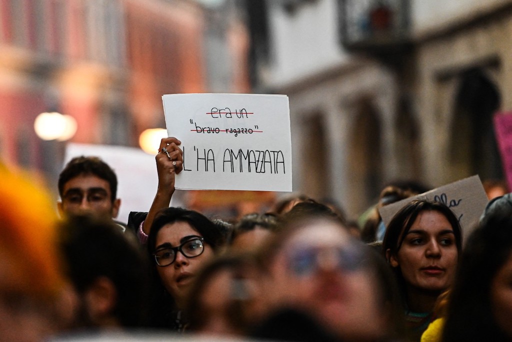 A woman holds a placard reading 'It was a good boy (crossed out) - He killed her' during a protest in Milan on November 22, 2023. 