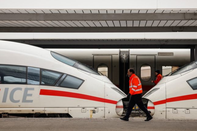 Employees walk past ICE high-speed trains that are standing still in Munich's main station.