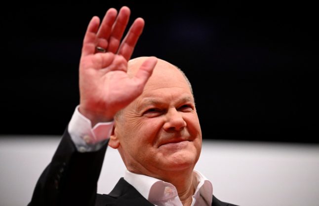 German Chancellor Olaf Scholz waves after giving a speech during the SDP congress. He has ruled out cutting welfare spending.
