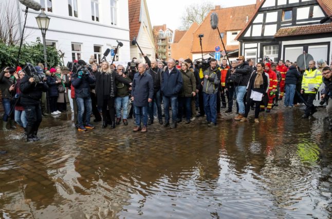 German Chancellor Olaf Scholz (C-L) and Lower Saxony's State Premier Stephan Weil (C) look at the flood waters and damage in Verden, western Germany