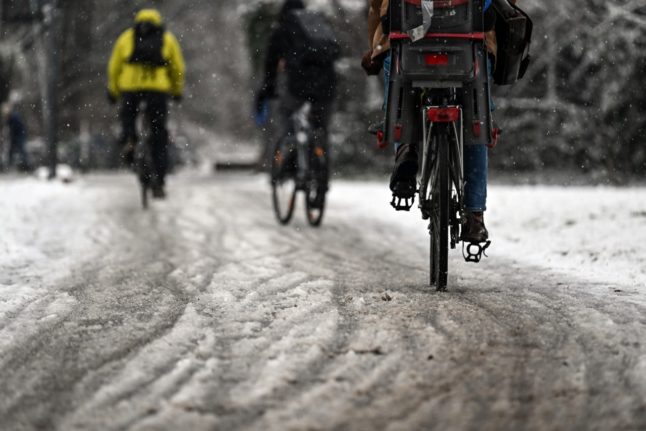 Cyclists ride through the snow in Cologne, Germany