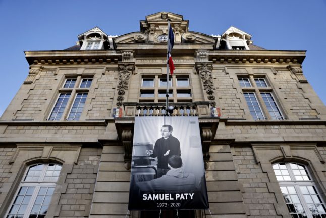 A poster of murdered teacher Samuel Paty hangs outside a city hall north-west of the French capital.