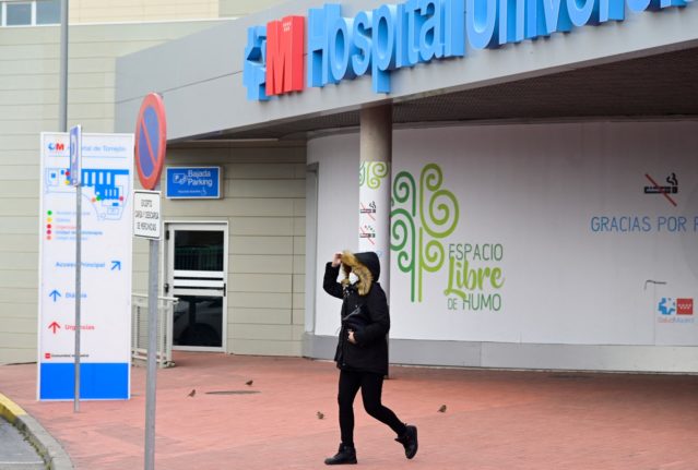 A woman wearing a face mask leaves Torrejon de Ardoz University Hospital, near Madrid