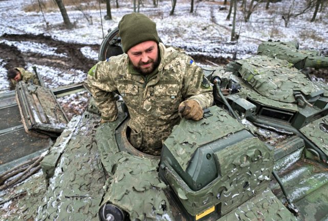A Ukrainian serviceman stands atop his Sweden-made CV90 combat vehicle in the Donetsk region