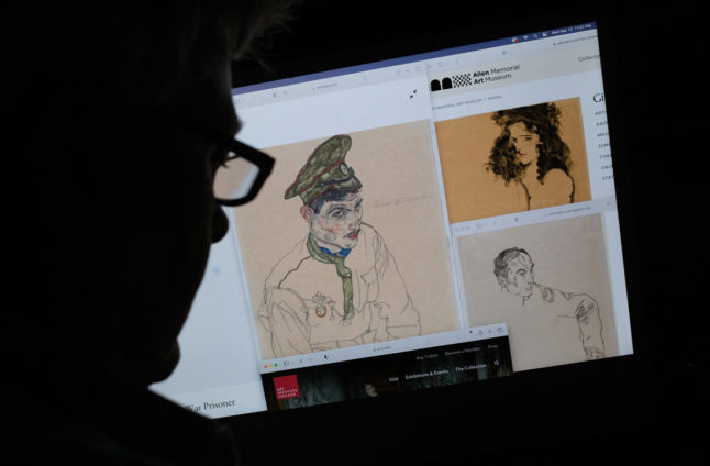 This photo illustration created on September 13, 2023 shows a person looking on a computer screen at artwork by Austrian expressionist Egon Schiele entitled 