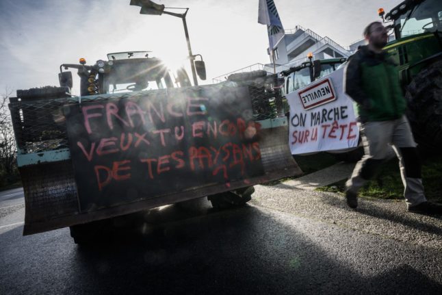 A farmer drives his tractor displaying a placard reading 'France, do you still want your farmers?' during a demonstration called by the main French unions to protest against agricultural policy in Rennes