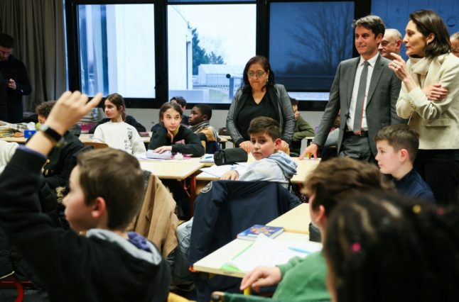 French Prime Minister Gabriel Attal and French Minister of Education, Sports, and Olympic Games Amelie Oudea-Castera speak to pupils during a visit to Saint-Exupery College, north west of Paris