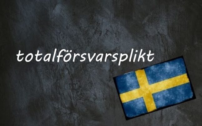 the word totalförsvarsplikt written on a blackboard next to the swedish flag