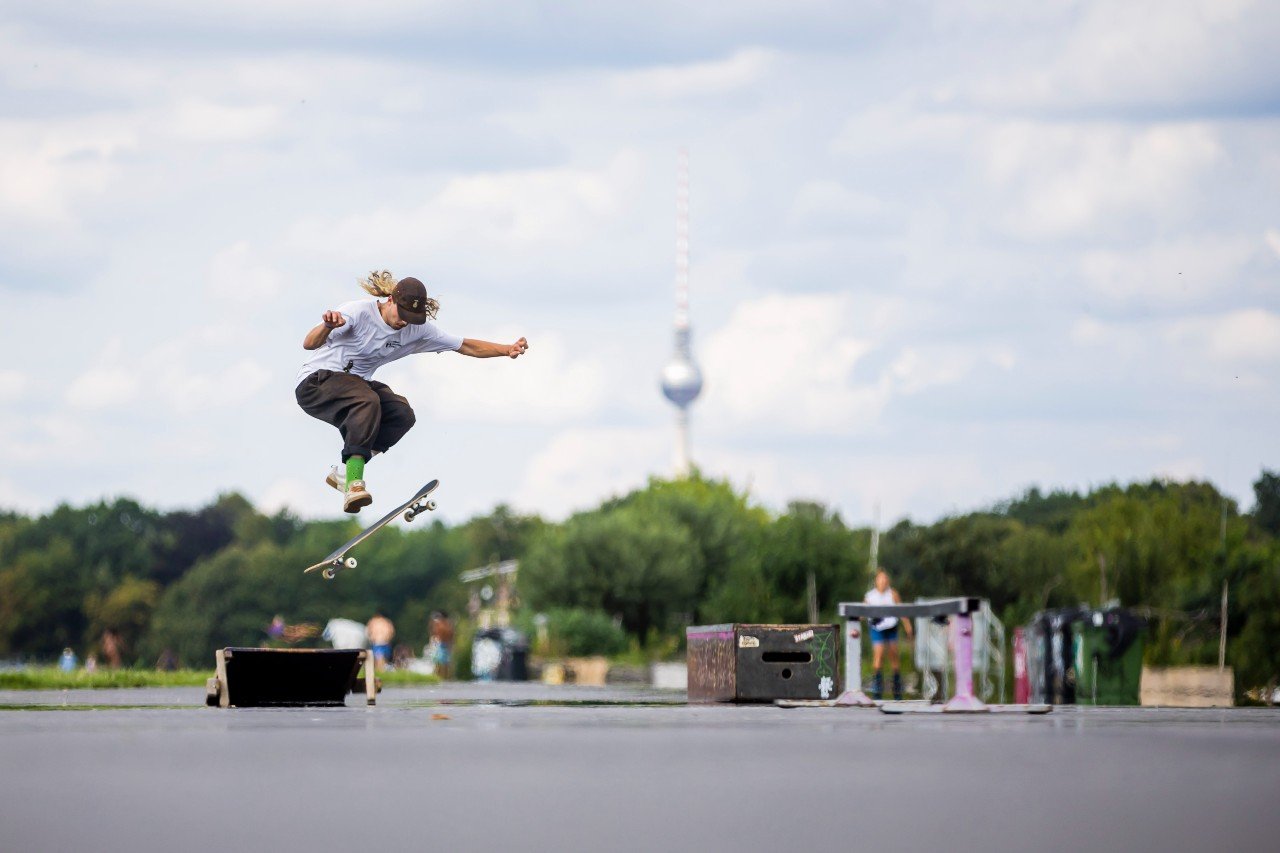 A skateboarder performs tricks on Tempelhofer Feld
