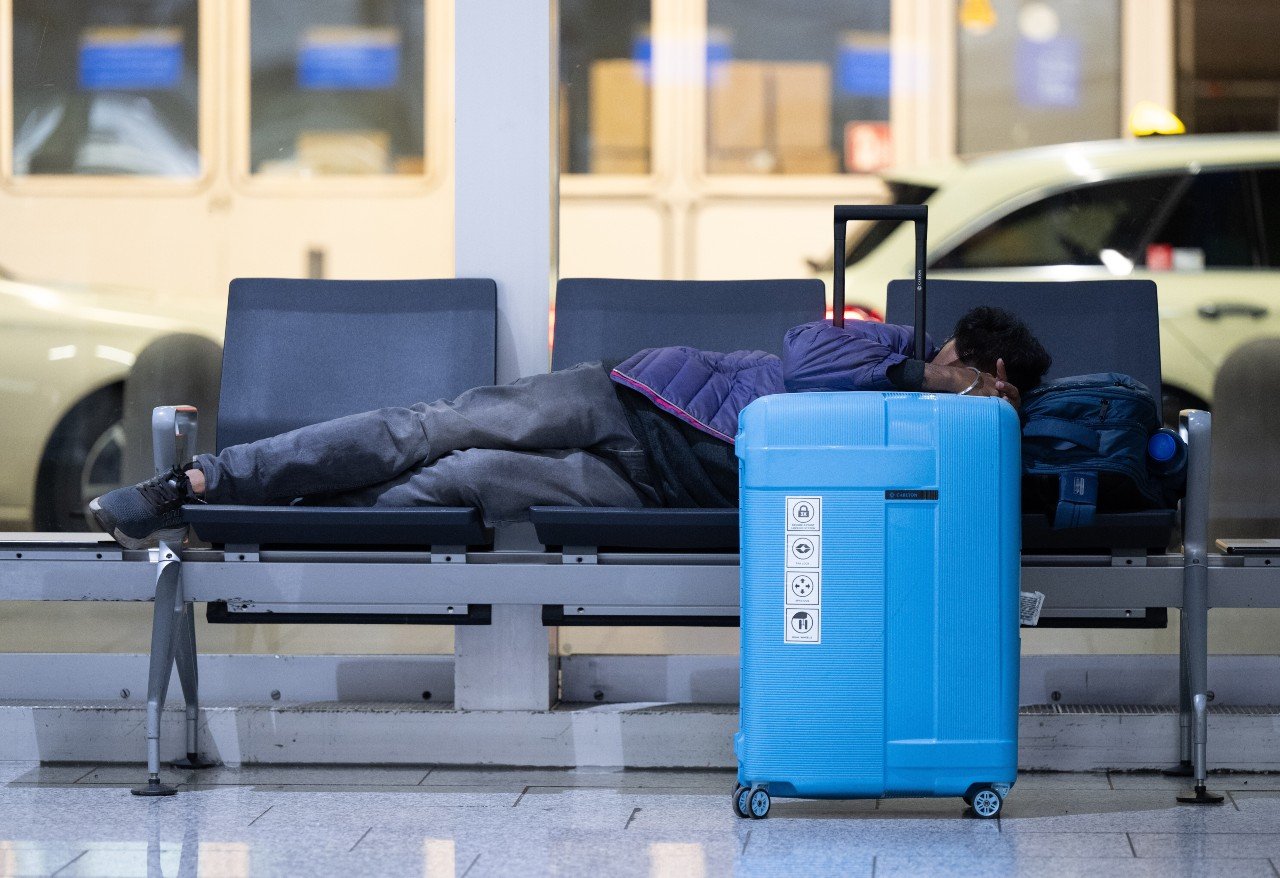 A man sleeps on a bench at Frankfurt airport during the Lufthansa strike.