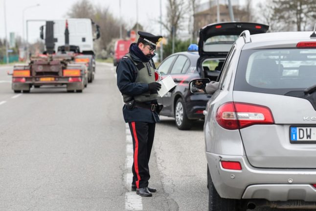 An Italian Carabinieri police officer checks a driver's papers.
