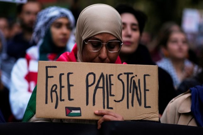A woman holds a sign reading “Free Palestine