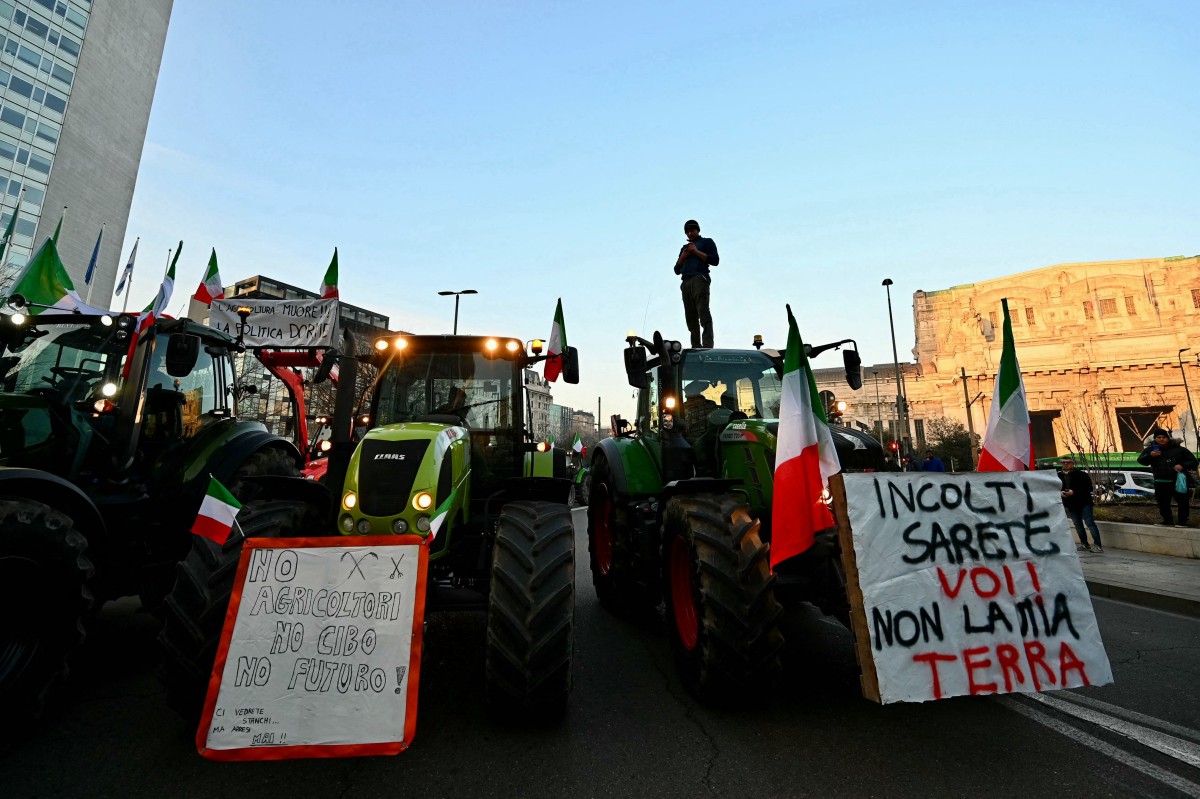 An Italian farmer stands on a tractor in the center of Milan during a protest on February 1, 2024. A placard (L) reads 'No agriculture, No food, no future'