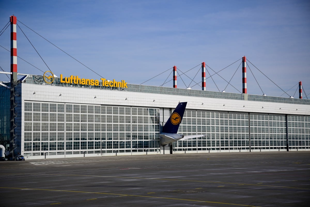 The tail of an airplane belonging to the German carrier Lufthansa is seen poking out from a hangar door at Munich international airport