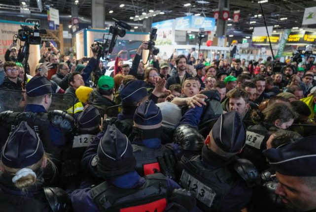 Angry farmers shuffle with French police officers, as French President tours the exhibition